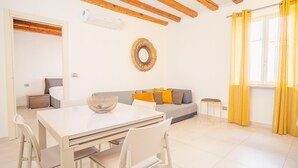 A modern living room with a dining table, sofa, and a decorative mirror. - San Giovanni in Valle - Italian Homing (Verona)