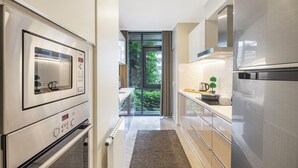 Una cocina moderna con electrodomésticos de acero inoxidable, un ventanal y vistas al exterior.