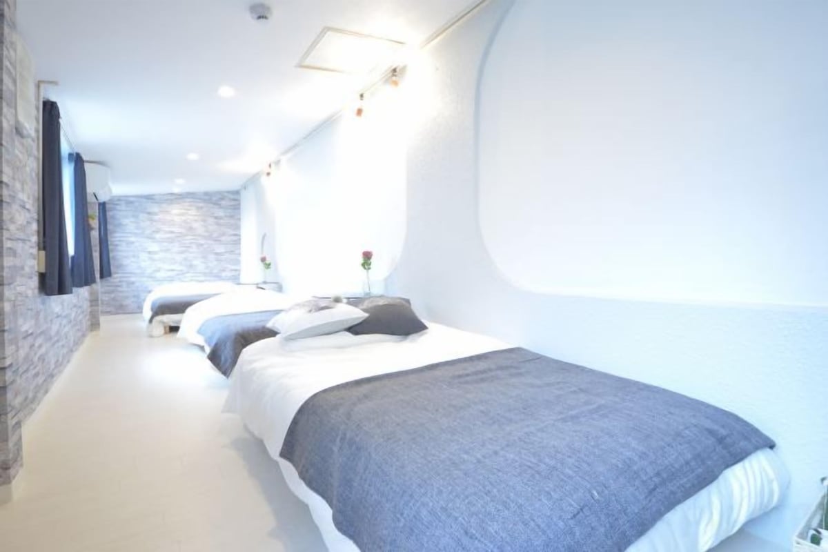 A bedroom with a bed, a bedside table, and a wall-mounted TV.