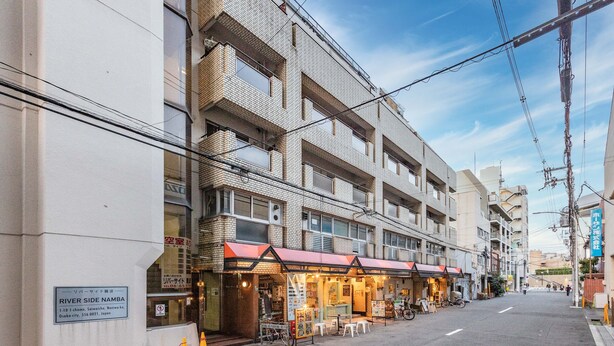 A multi-story building with a ground-level commercial space featuring a storefront with outdoor seating. - Riverside Namba  (Osaka)