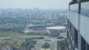 A high-rise building overlooking a cityscape with two large stadiums and numerous high-rise buildings.