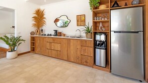 A modern kitchen with wooden cabinets, a stainless steel refrigerator, a coffee maker, and various decorative items. - Cozy 4BR Villa With Amazing Pool Area, Bali Villa 2210 (Seminyak)