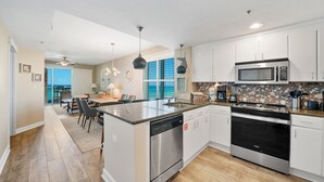 Una cocina moderna con electrodomésticos de acero inoxidable, una isla central y un comedor con vistas.
