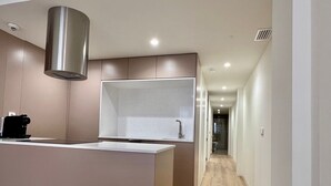 Eine moderne Küche mit integrierter Kochinsel, Edelstahl-Dunstabzugshaube und minimalistischem Design.