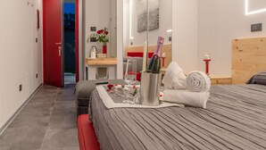 A modern hotel room with a bed, bedside table, and a mirror. - Le Nazioni B&B (Comacchio)