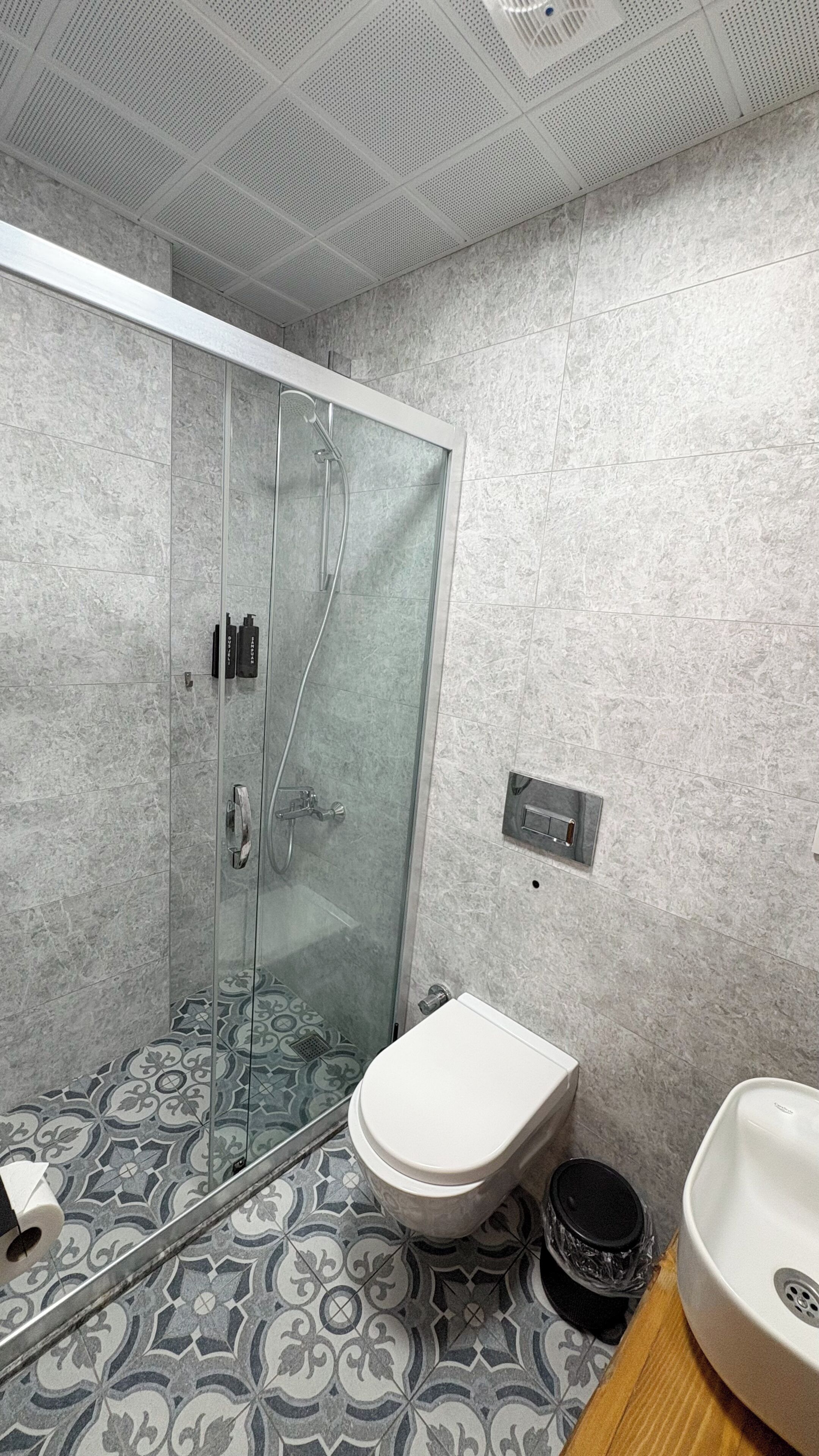 Un baño con ducha, inodoro y lavabo.