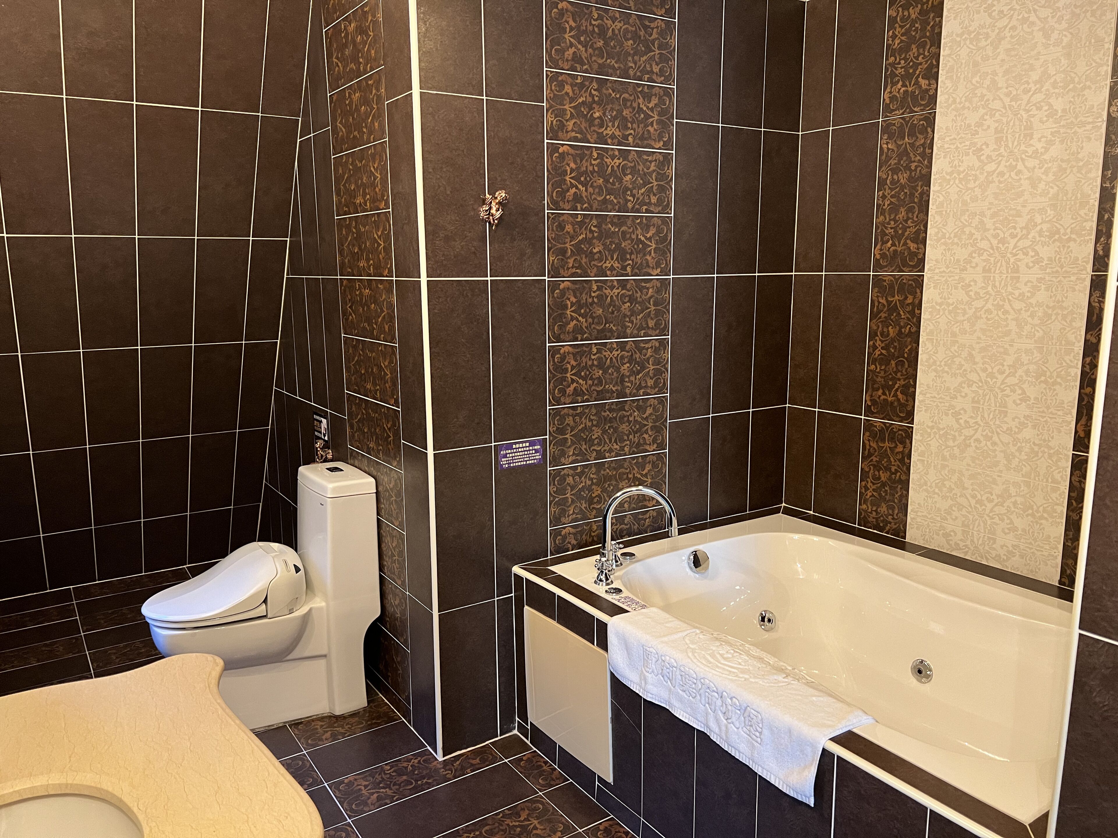A modern bathroom with a toilet, bidet, and bathtub.