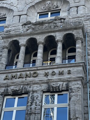 A building facade with the inscription "AMANO HOME" and classical architectural elements including columns and decorative carvings. - AMANO Home Leipzig (Leipzig)