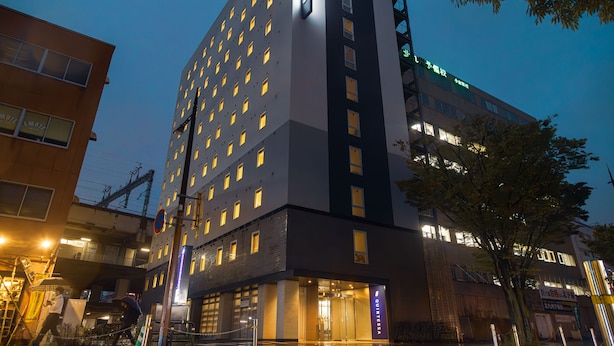 A multi-story hotel with a modern design, featuring a prominent entrance and multiple windows.