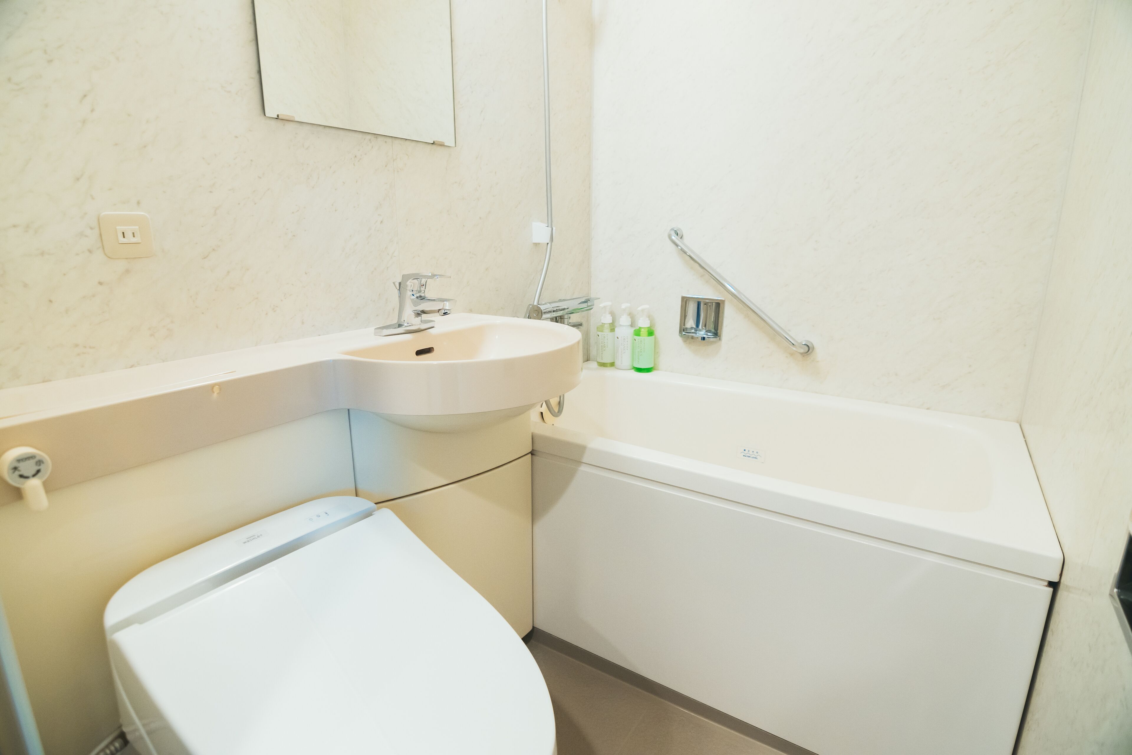 Et badeværelse med toilet, håndvask og badekar.
