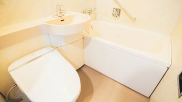 A bathroom with a toilet, sink, and bathtub.