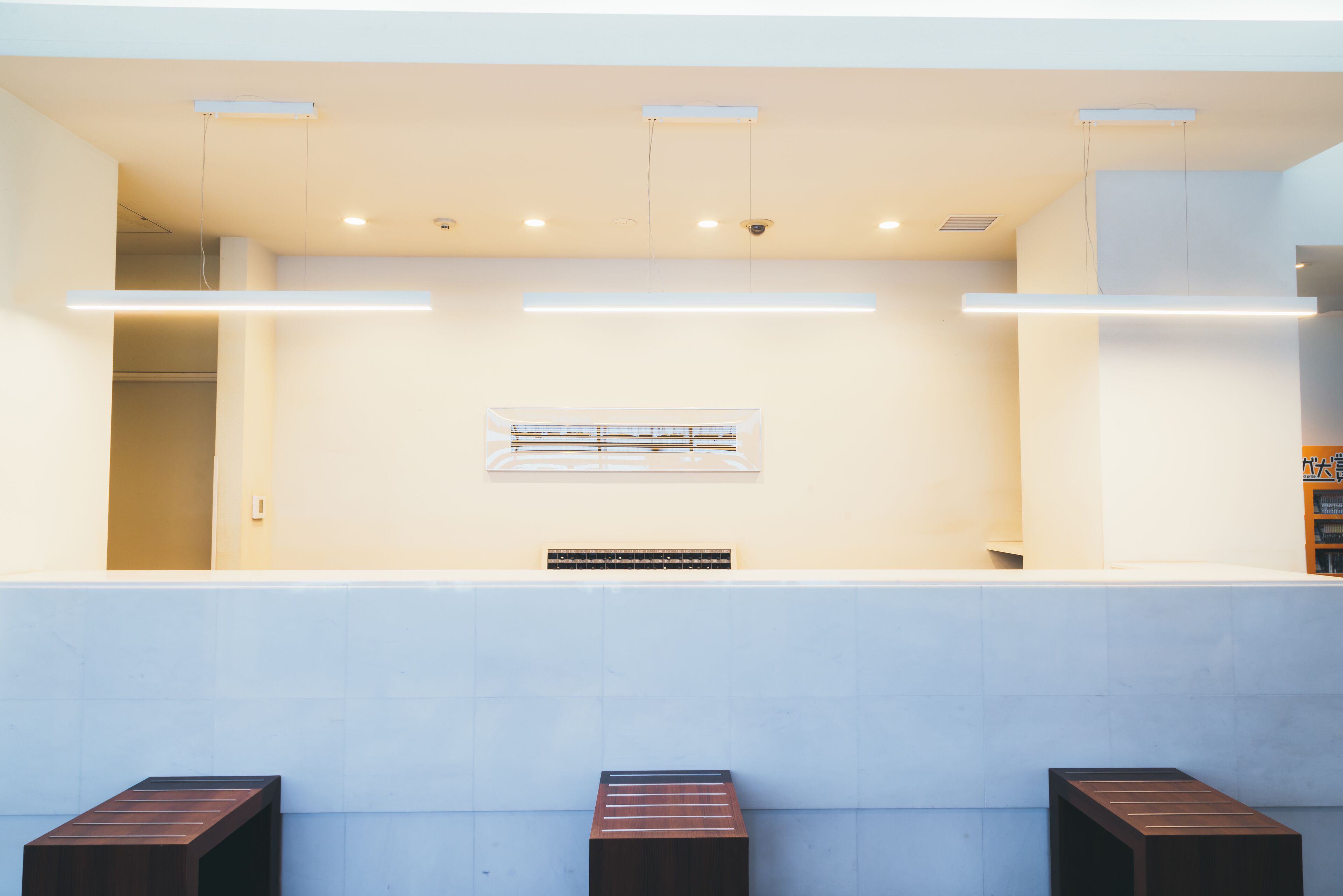 A reception area with a counter, seating, and a wall-mounted sign.