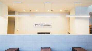 A reception area with a counter, seating, and a wall-mounted sign.