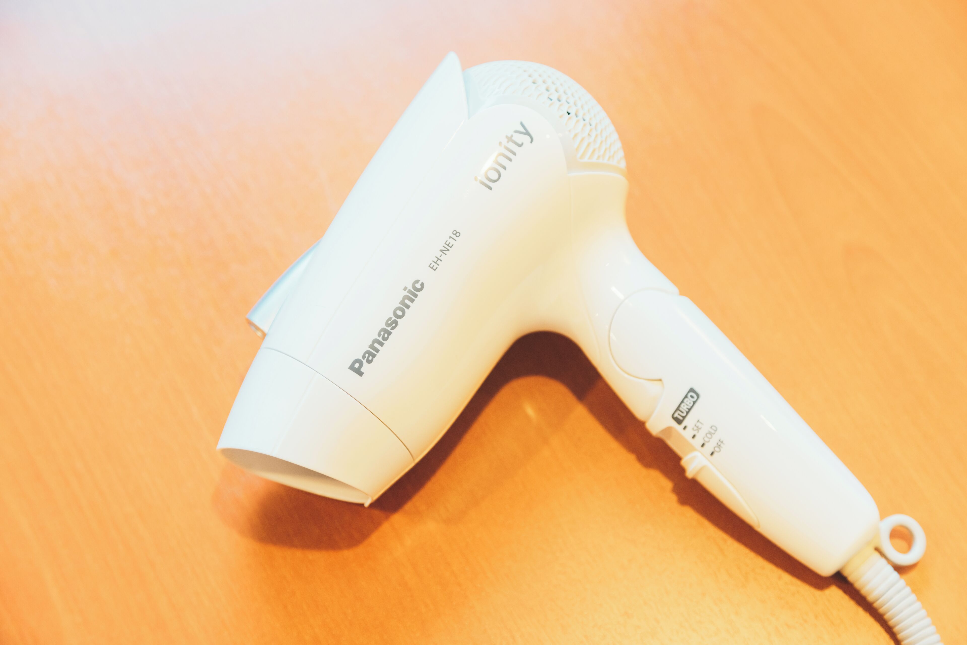 Secador de cabelo Panasonic ionity sobre uma superfície de madeira.