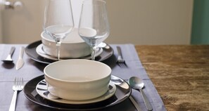 A dining table with a bowl, two wine glasses, and cutlery. - Charming Modern Apartment (Como)