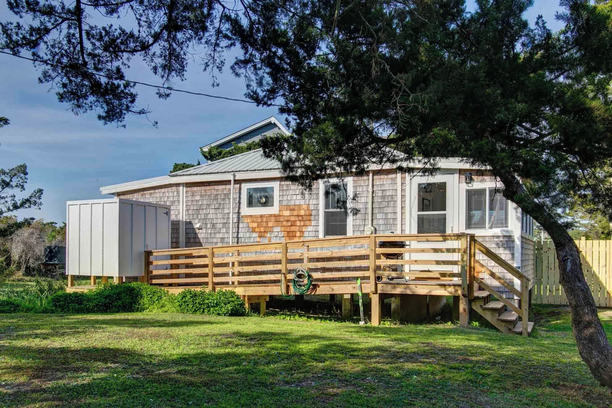 A single-story house with a wooden deck and a covered porch.