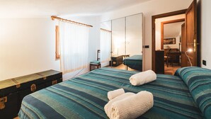 Une chambre d’hôtel comprenant un lit, un bureau, une chaise, un miroir et une armoire.