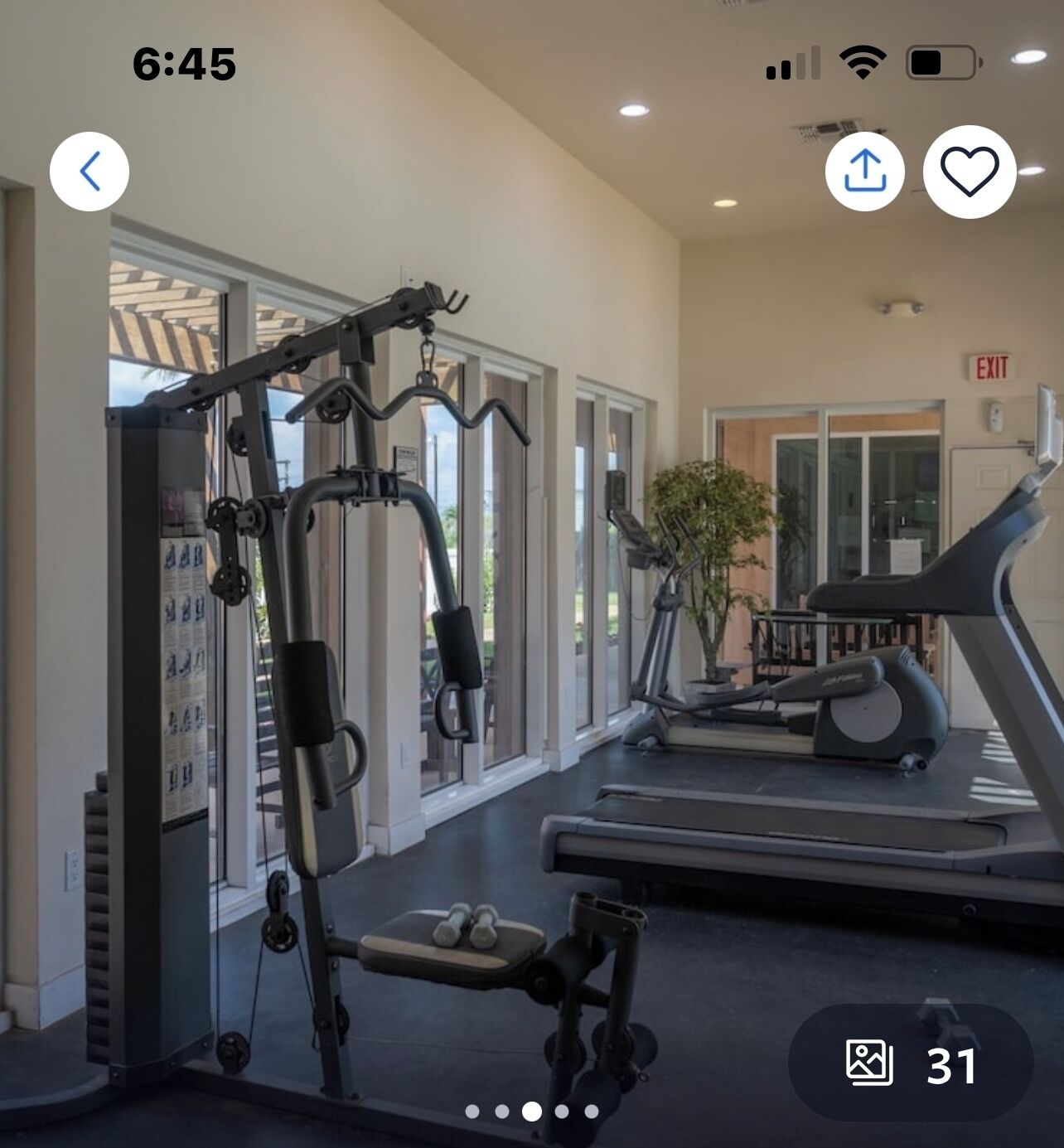 A gym with cardio equipment, weight machines, and a treadmill.