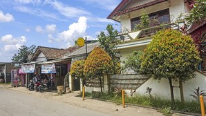 A residential area with houses, a motorcycle parked in front, and a signboard. - Hotel O Wisma Asri Putra Syariah (Ciampia)