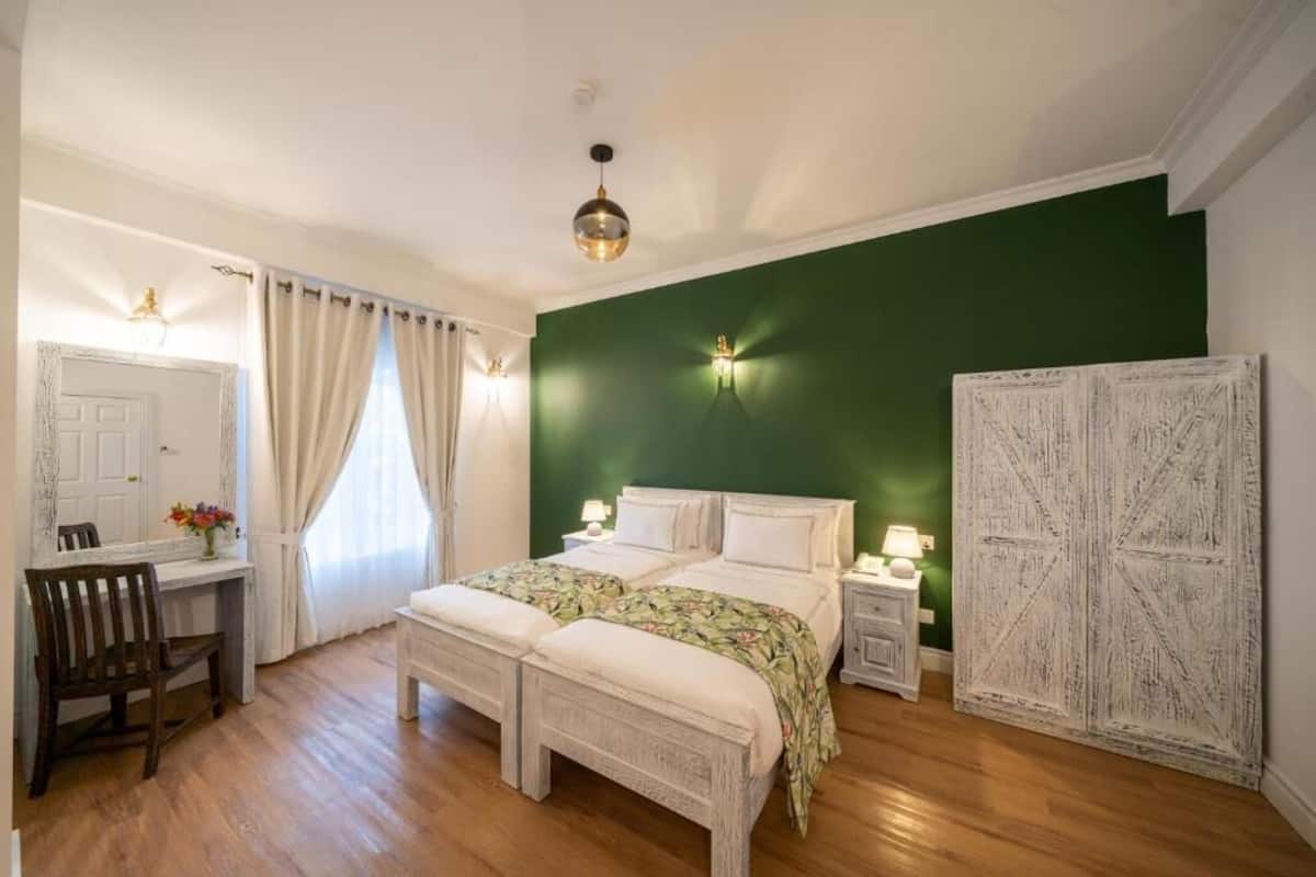 Ein Schlafzimmer mit einem Bett, Nachttischen, einem Schreibtisch und einem Stuhl.