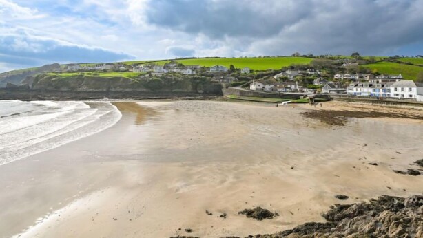 A coastal beach with a sandy shore, a small town in the background, and a clear sky. - Blue Crab by Interhome (Mevagissey)