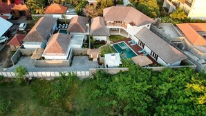 An aerial view of a residential area with multiple houses, a swimming pool, and lush greenery. - Luxurious 4BR Villa With Pool, Bali Villa 2206 (Seminyak)