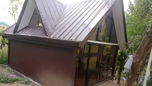 Un piccolo edificio a un piano con tetto spiovente e ampie vetrate.