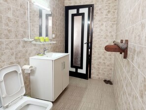 Suite estudio Deluxe | Baño | Ducha, cabezal de ducha tipo lluvia, zapatillas y toallas