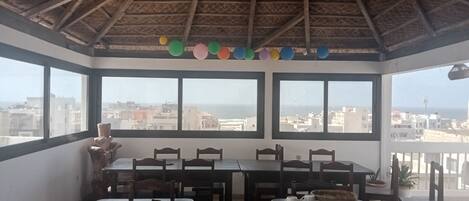 Una habitación con techo de paja, ventanas amplias y suelo de baldosas.