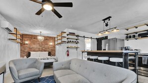Una sala de estar moderna con un sofá, una mesa de centro y un comedor con una cocina al fondo.