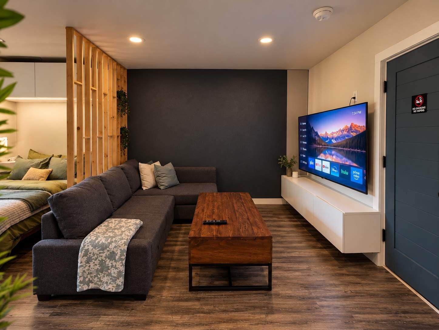 Una sala de estar moderna con un sofá modular, una mesa de centro de madera y un televisor de pantalla plana montado en la pared.