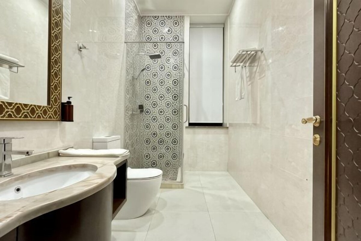 A modern bathroom with a large sink, toilet, and shower area.