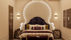 Un dormitorio lujoso con una elaborada cabecera, una cama cómoda, apliques decorativos y una mesita de noche.