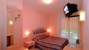 A bedroom with a bed, bedside tables, a mirror, a television mounted on the wall, and a window with curtains. - hotel CASABLANCA (Lazise)