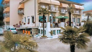A hotel with a bar, outdoor seating, and a pool area. - hotel CASABLANCA (Lazise)