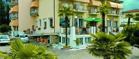 A hotel named "CASABLANCIA" with a bar on the ground floor, multiple balconies, and a well-maintained garden with palm trees.