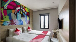 A hotel room with two beds, a large mural on the wall, a TV mounted on the wall, and a window with blinds. - Collection O Bekasi Timur Near Gedung Juang Formerly Regia Tambun (Cikarang)
