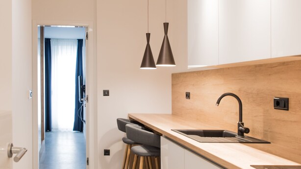 A modern kitchen with a wooden countertop, a sink, and pendant lighting. - Deluxe, Charming and Cozy Bcadria Apartment A2 (Split)