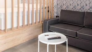 A modern living room with a grey sofa, a white coffee table, and a wooden partition. - Deluxe, Charming and Cozy Bcadria Apartment A2 (Split)