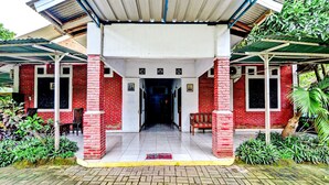 A building with a covered entrance, red brick walls, and a tiled floor. - OYO 90222 Lafa Park Syariah (Cikarang)