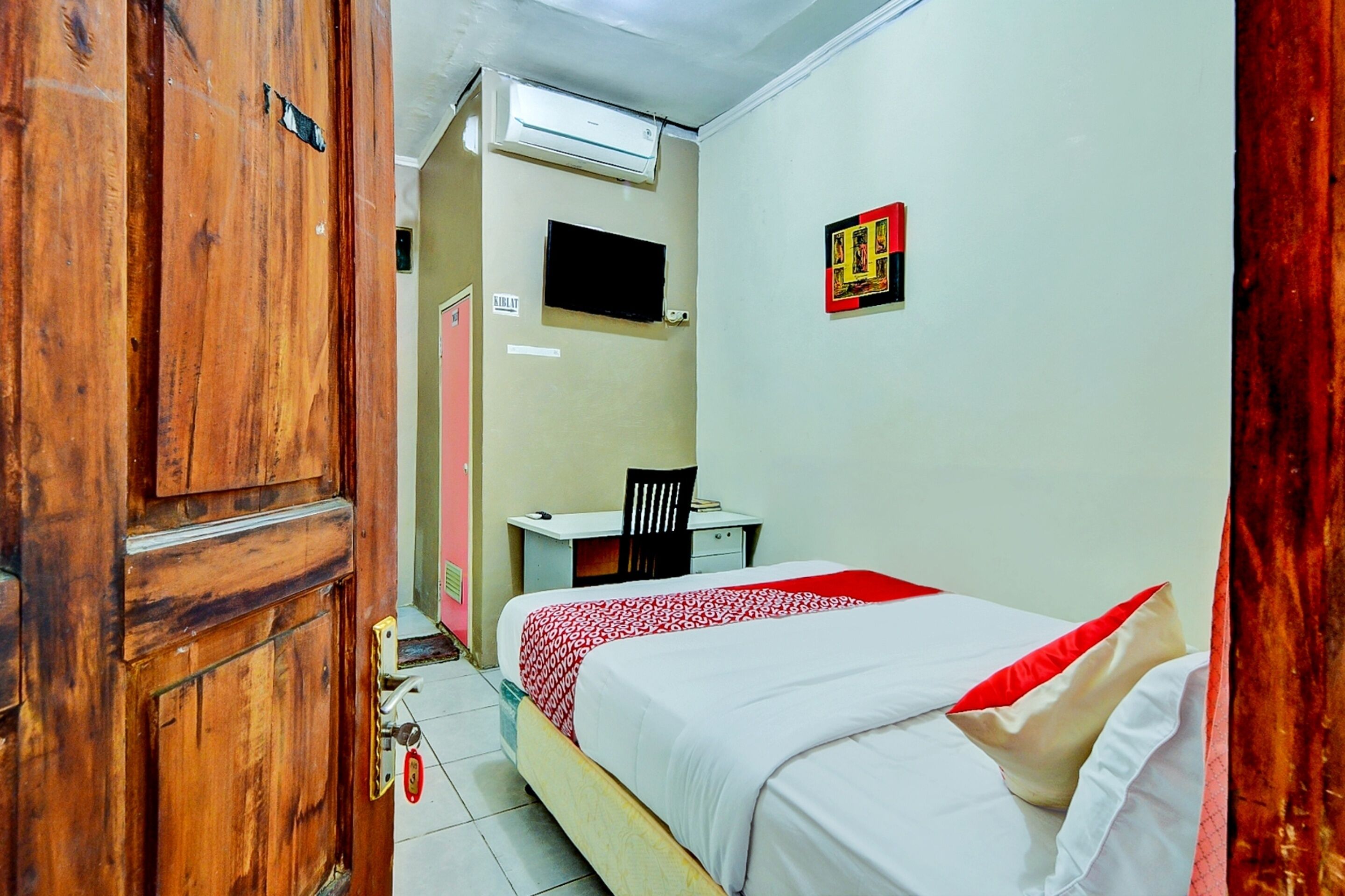 Un dormitorio con cama, escritorio y silla.