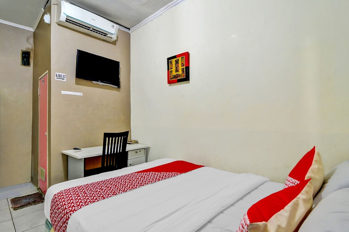 Une chambre comprenant un lit, un bureau, une chaise, un téléviseur et un appareil de climatisation.