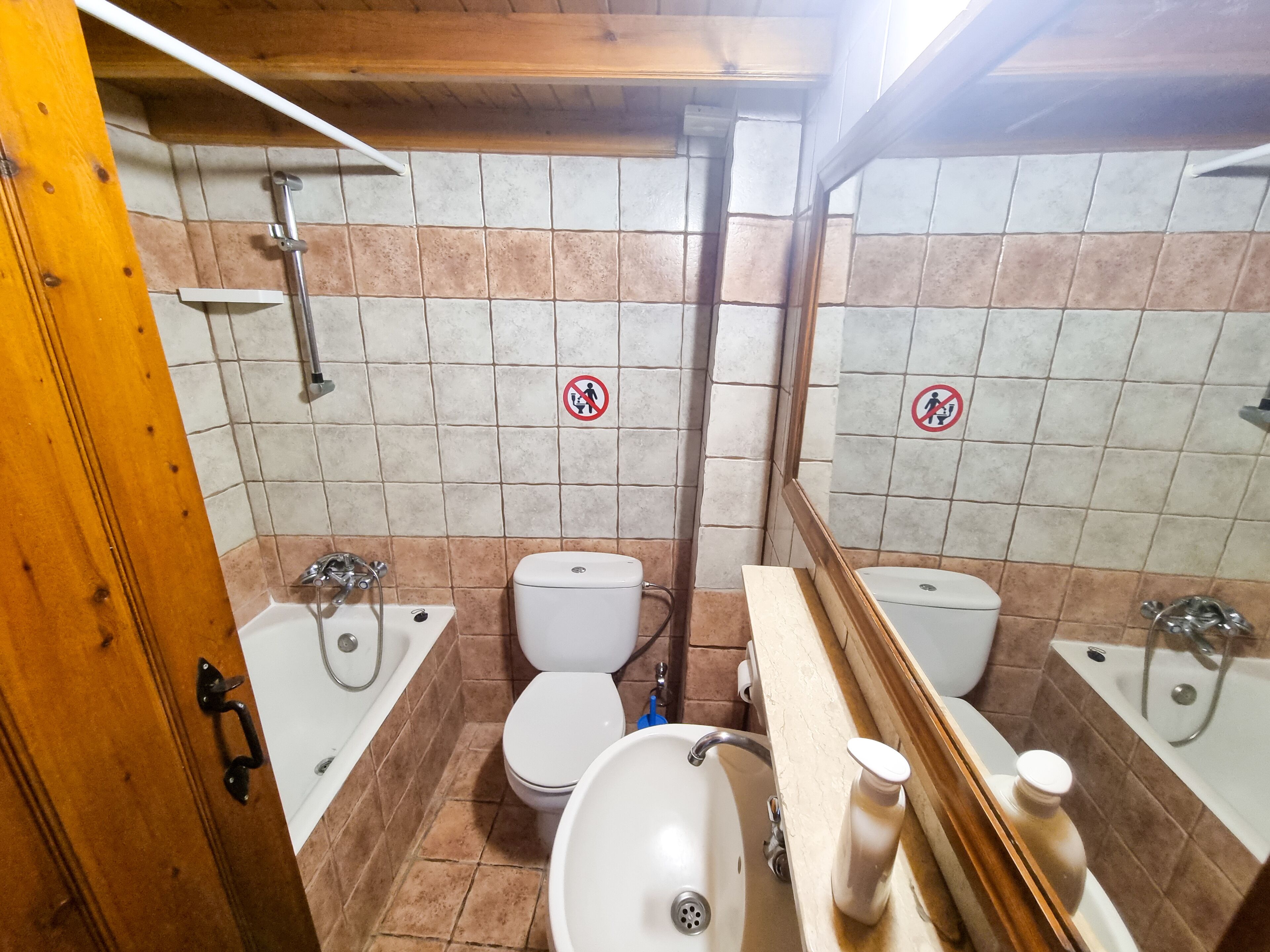 A bathroom with two toilets, a sink, and a shower.