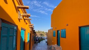 Eine schmale Straße mit orangenen Gebäuden, Pflastersteinen und blauen Fensterläden.