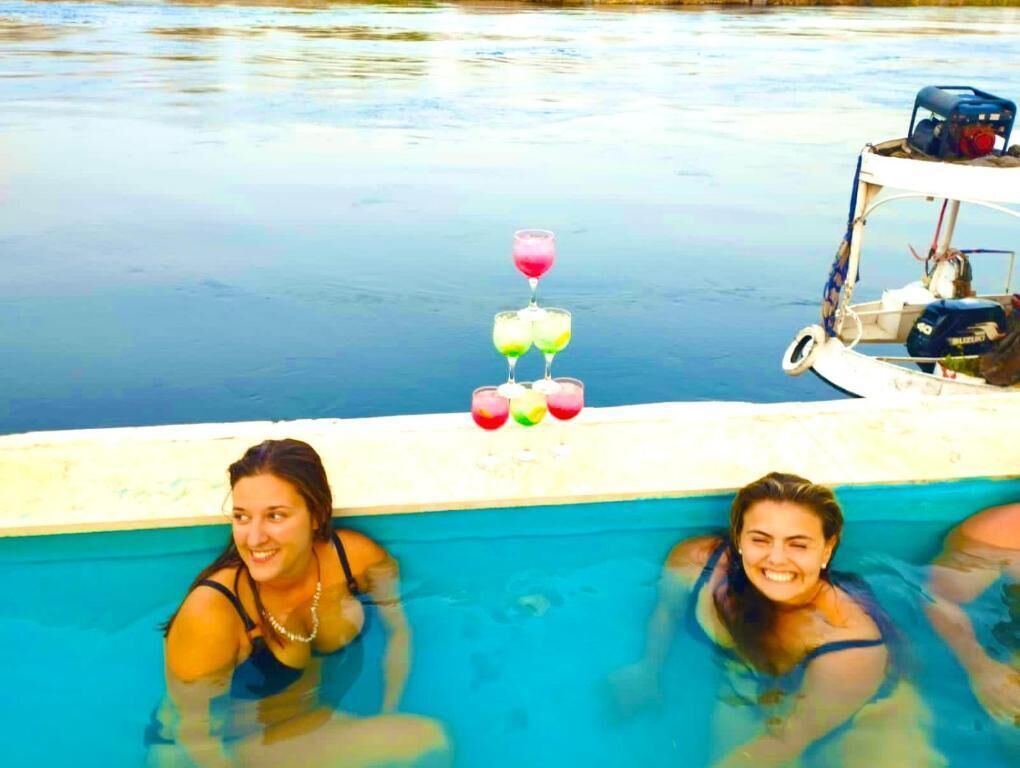 A swimming pool with a drink stand and a boat.