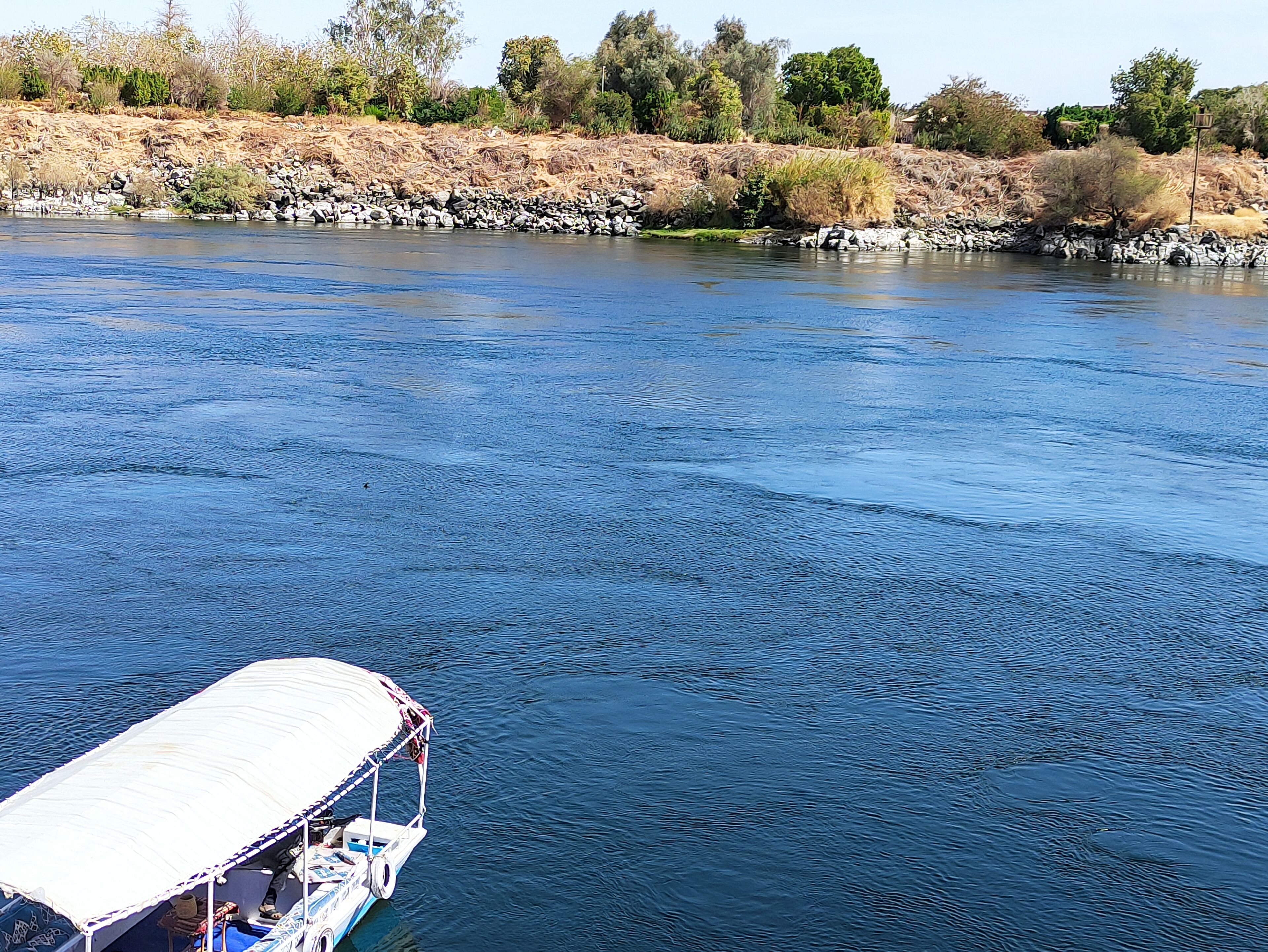 A river with a boat docked on the left.