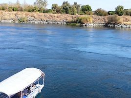 Un río con una barca atracada a la izquierda.