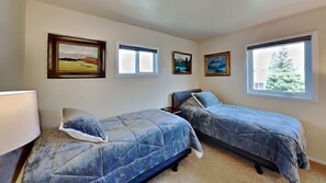 A bedroom with two beds, a lamp, and three framed pictures on the wall. - Cozy country-style home, relaxing views off the deck, and dog friendly! (Silverthorne)