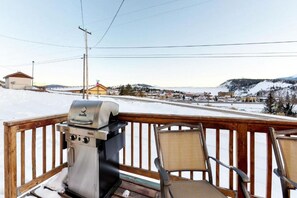 A deck with a grill, chairs, and a snowy landscape in the background. - Cozy country-style home, relaxing views off the deck, and dog friendly! (Silverthorne)