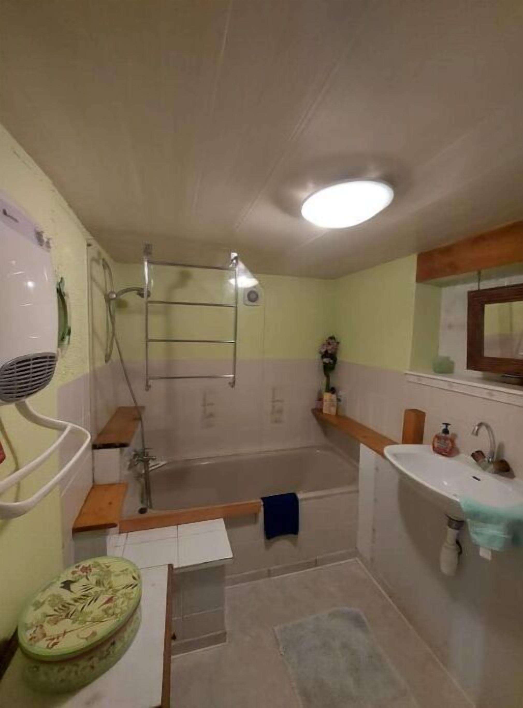 A bathroom with a bathtub, a sink, a mirror, and a shower.